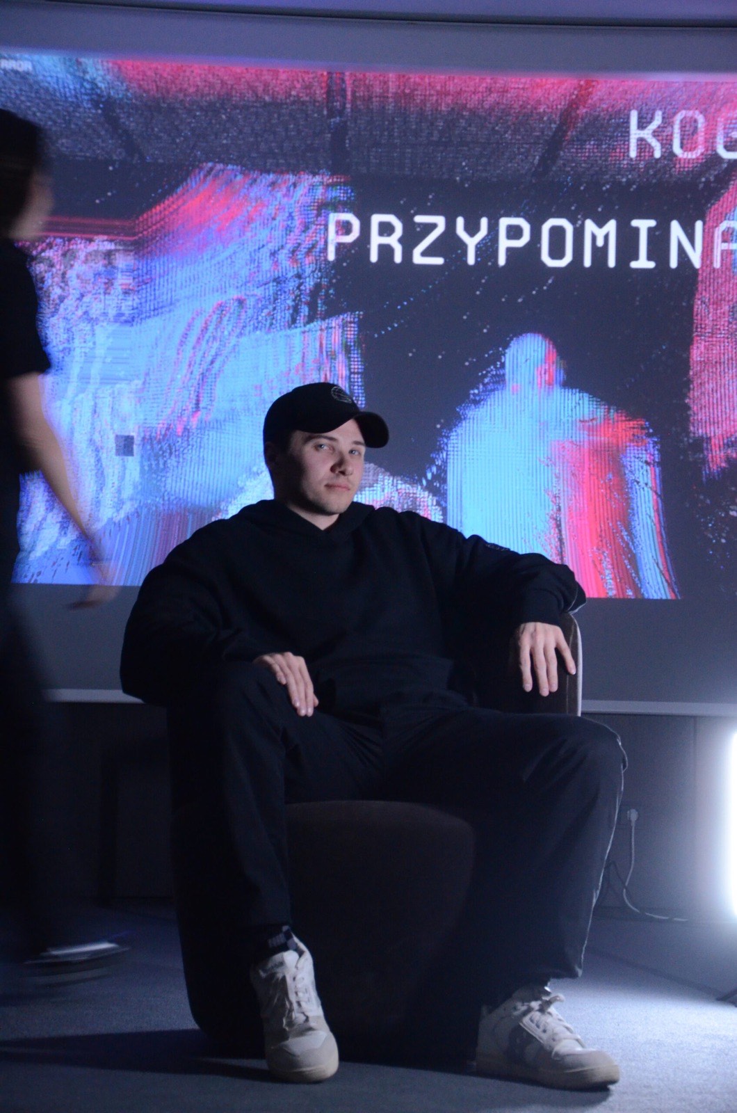 Kacper sitting in front of a projected screen
